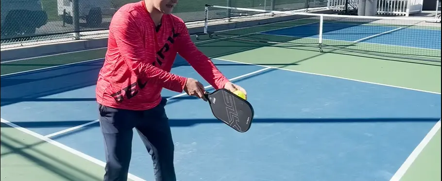Pickleball player's close-up focusing on serve technique with paddle