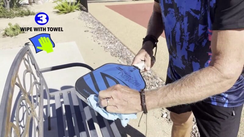 drying pickleball paddle wiping with towel